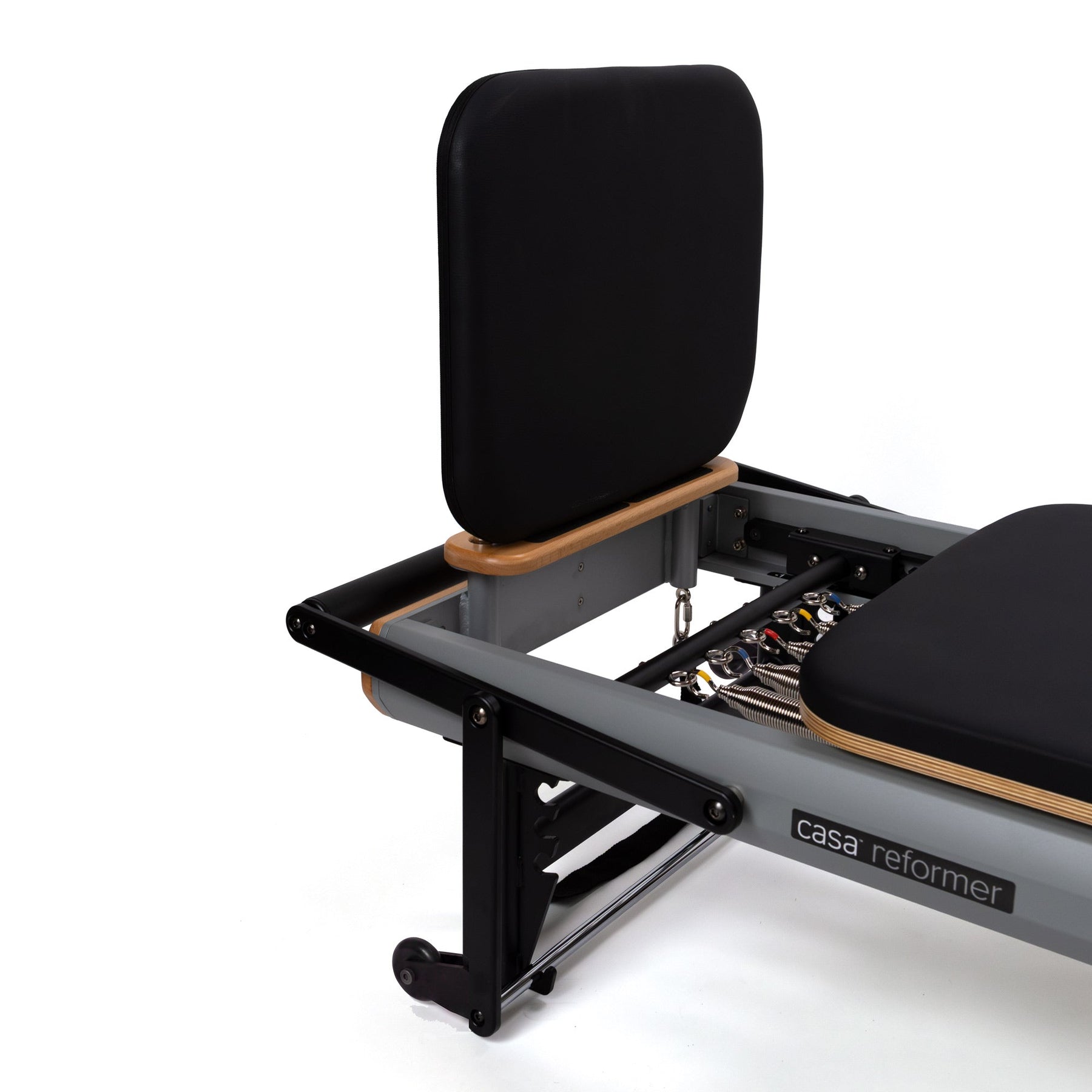 Padded jump board fitted upright at the foot end of a Peak Pilates casa reformer with an aluminium frame