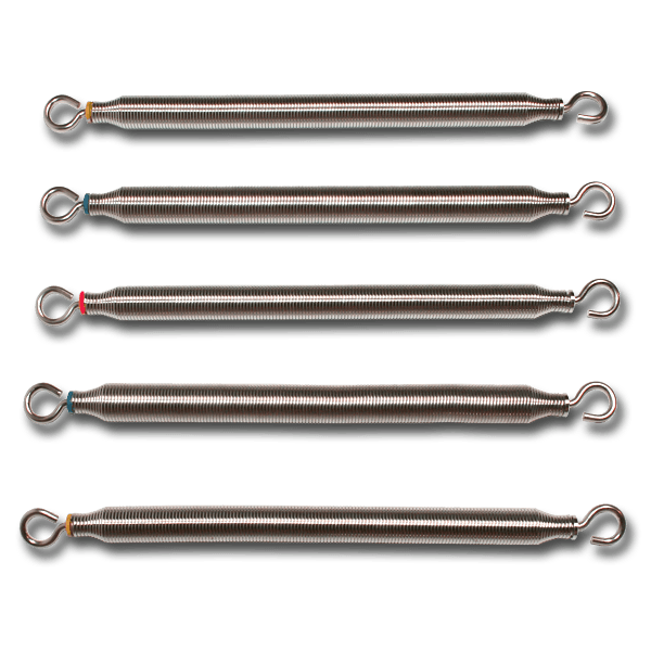 Five reformer springs with red, yellow and blue tension markers laid side by side on a dark background
