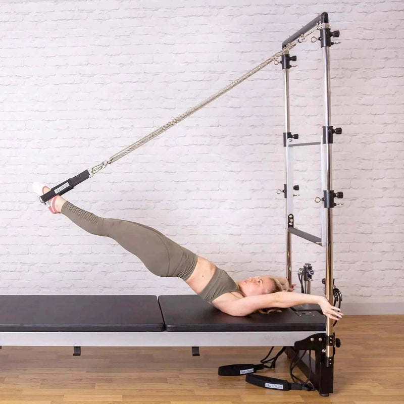 Align Pilates A8-Pro with Half Cadillac, user lying on the bed with feet in the tower springs