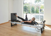 Align Pilates A8-Pro, client lying on a sitting box in a bright studio