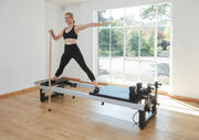 Align Pilates A8-Pro, standing exercise with a pole in a bright studio