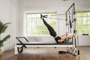Align Pilates C8-S with Half Cadillac, user lying back with feet in the tower springs