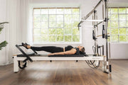 Align Pilates C8-S with Half Cadillac, user lying on the carriage in a studio