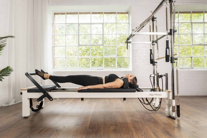 Align Pilates C8-S with Half Cadillac, user lying on the carriage in a studio