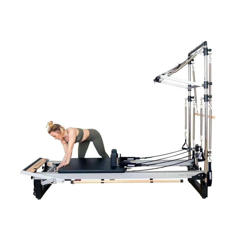Align Pilates Half Cadillac Frame, side view on a reformer with a woman kneeling on the carriage