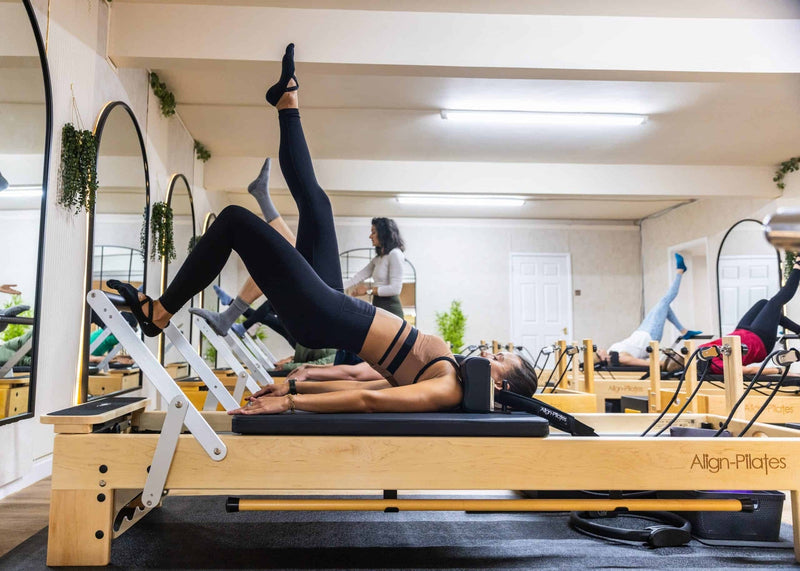 Align Pilates M8-Pro, client working with foot straps during a class