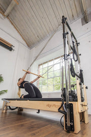 Align Pilates M8-Pro with Half Cadillac, user kneeling with a pole under the tower
