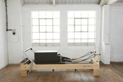 Align Pilates M8-Pro Reformer, angled studio view with a sitting box on the carriage