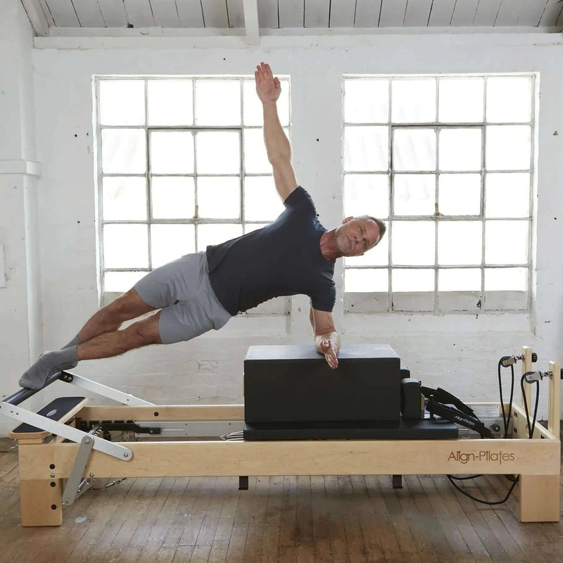 Align Pilates M8-Pro, instructor performing a side plank on the sitting box