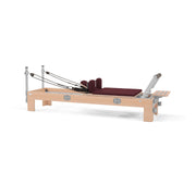 BASI Systems Compact Reformer upholstered in Burgundy, the whole apparatus shown against a plain background