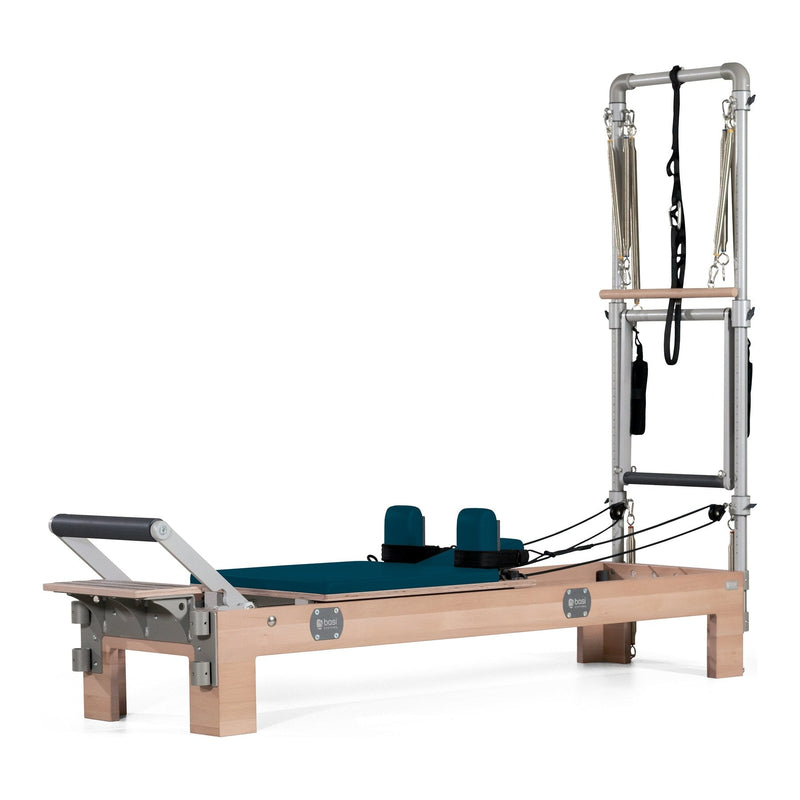 BASI Systems Compact Reformer with Tower upholstered in Petrol Green, the whole apparatus shown against a plain background