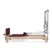 BASI Systems Reformer with Tower upholstered in Burgundy, the whole apparatus shown against a plain background, third view