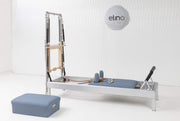 Classic Aluminium Reformer with Tower and sitting box in blue upholstery, showroom setting — made-to-order colourway