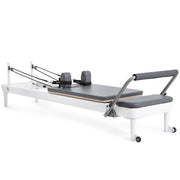 Elina Pilates Nubium Reformer, white aluminum frame with grey upholstery, angled studio view