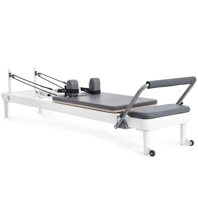 Elina Pilates Nubium Reformer, white aluminum frame with grey upholstery, angled studio view