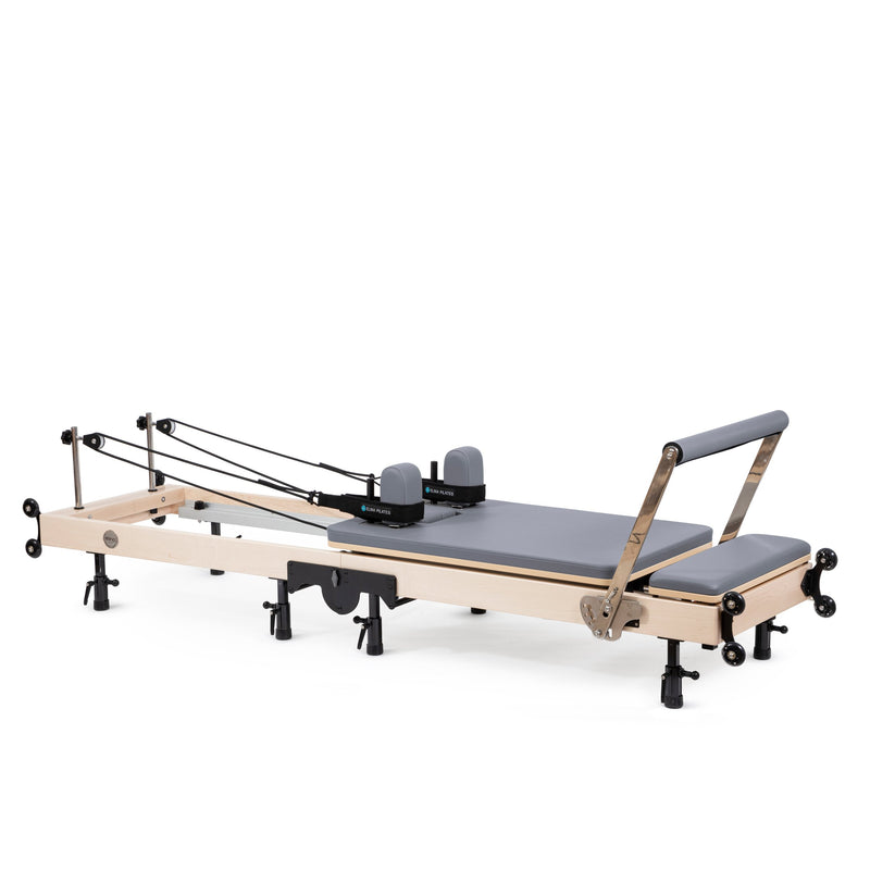 Elina Pilates Fold Reformer set up, maple frame with grey upholstery, angled view
